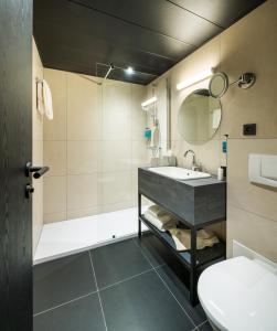 布鲁塞尔Hotel Hubert Grand Place的一间带水槽、浴缸和卫生间的浴室