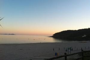 波多诺伏Chalet Arena de Canelas en 1ª línea de Playa, Sanxenxo的日落时分享有海滩和大海的景致