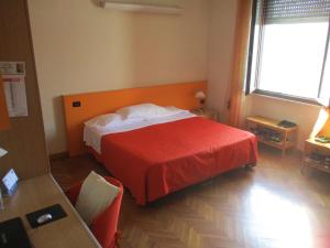 普拉托Affittacamere ACCASA的酒店客房,配有一张带红色毯子的床