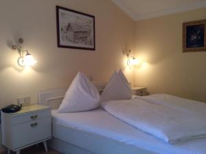 瓦格赖恩安贝格度假屋的一间卧室配有带白色床单和枕头的床。
