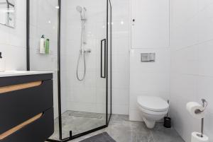 比亚韦斯托克CR Apartament Centrum Zamenhofa 1的带淋浴和卫生间的白色浴室