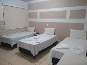 Rolim de MouraCrystal Palace Hotel的一间设有两张带白色床单的床的房间