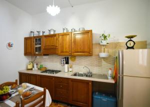 努奥罗Casa Marta IUN Q1985的厨房配有木制橱柜和白色冰箱。