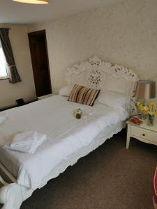 廷塔杰尔科里士满酒店的一张大白色的床,位于带桌子的房间