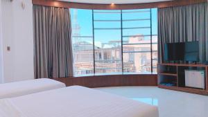 Long KhanhQuốc Thanh Hotel的酒店客房设有两张床和大窗户。