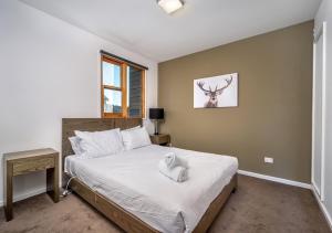 丁诺高原Triggerplant 4的一间卧室配有一张带白色毛巾的床
