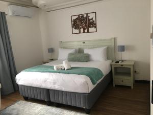 乌姆塔塔Omaha Luxury B&B/Spa的一间卧室配有一张大床和两条毛巾