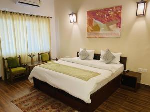 瑞诗凯诗圣斯奎提吠陀度假酒店的一间卧室配有一张大床和两把椅子