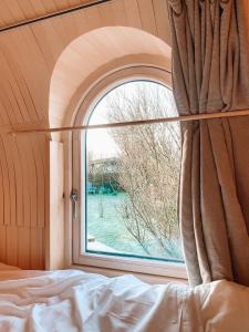 卡兰茨奥赫Igluhut De Keet, in Natuurgebied en vlakbij het Strand的卧室设有拱形窗户和1张床