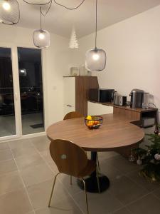 艾克斯莱班LES MYRTILLES Aix les Bains的厨房配有木桌、椅子和吊灯