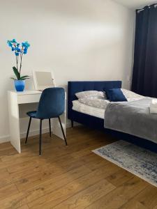 格丁尼亚Apartament Wiczlino的一间卧室配有一张床、一张桌子和一把椅子