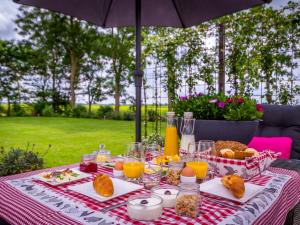 WieringerwaardVakantiewoningen Prelude & Etude的一张带食物和饮料的野餐桌和一把雨伞