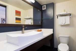 檀香山威基基VIVE酒店的浴室设有白色水槽和镜子
