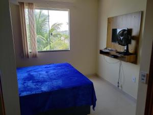 伊利利Casa Duplex Iriri - Banheira e Piscina的一间卧室设有蓝色的床和窗户。