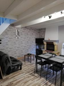 SarceauxAu Petit Bezion的客厅配有桌椅和砖墙