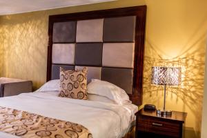 萨利达盖特威旅馆及套房的一间卧室配有一张带大床头板的床