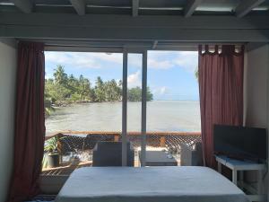 莫雷阿Bungalow blue lagon waterfront的一间卧室配有一张床,享有海景