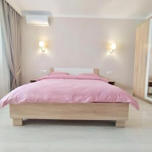 敖德萨квартира в Жилом комплексе Левитана,массив Радужный的一间卧室配有一张粉红色的床和两盏灯
