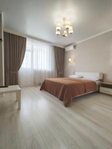 敖德萨квартира в Жилом комплексе Левитана,массив Радужный的一间卧室配有一张大床和一个吊灯。