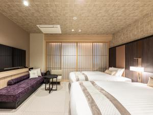 京都Hotel Musse Kyoto Shijo Kawaramachi Meitetsu的酒店客房,设有两张床和一张沙发