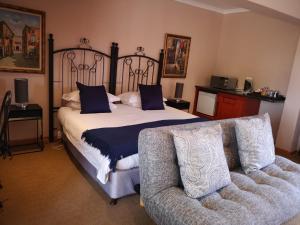 阿多卡萨米亚健康水疗及旅馆的一间卧室配有一张大床和一张沙发