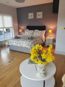 KilmeadenGreenmile House,的一间卧室配有一张床和一张鲜花桌