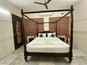 艾哈迈达巴德Casa Blanca - A Boutique Resort的一间卧室配有一张带木框和两个弓的床铺