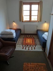 阿灵厄Store Lærkegård的客房设有两张床、一张沙发和一个窗口。