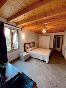 托斯科拉诺-马德尔诺Atlante的一间带一张床的卧室,位于带木制天花板的房间内