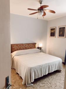 托斯科拉诺-马德尔诺Atlante的一间卧室配有一张带吊扇的床