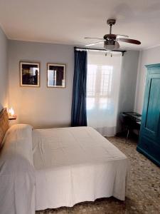 托斯科拉诺-马德尔诺Atlante的卧室配有白色的床和蓝色的窗户。