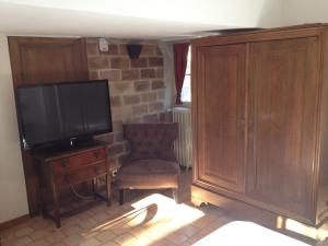 ChamantHotel L'Aunette Cottage的客厅配有电视、椅子和橱柜