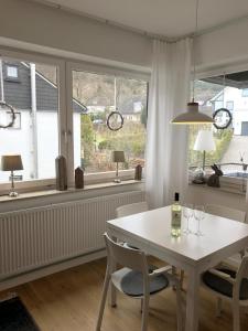 施马伦贝格Ferienwohnung Gierse的一间设有白色桌子、椅子和窗户的用餐室