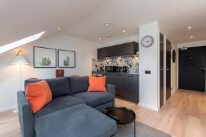 爱丁堡Destiny Scotland Market Street Apartments的一间带蓝色沙发的客厅和一间厨房