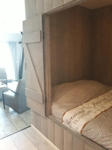 霍尔沃德De Bedstee的一间卧室,配有一张位于带镜子的橱柜内的床铺