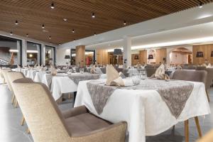 利维尼奥普卡尼维酒店的一间设有白色桌椅的用餐室