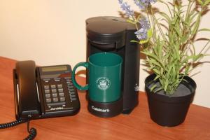 埃德蒙顿阿尔伯塔大学酒店的坐在电话和盆子旁的绿色咖啡杯