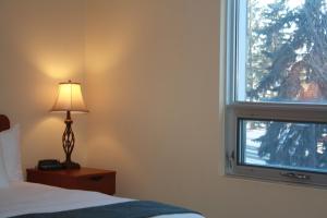 埃德蒙顿阿尔伯塔大学酒店的一间卧室设有一张床和一个窗口