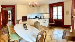 Cormondrechel'Attique du Château的厨房配有白色的大桌子和椅子