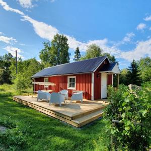 HammarstrandGuesthouse 'Lodge Lagom' ~ Hammarstrand-Jämtland的庭院中带木甲板的红色谷仓