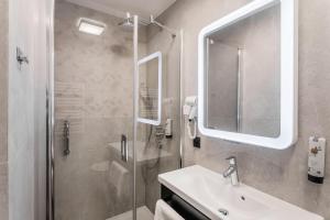 格但斯克Hotel Vesper House的带淋浴、盥洗盆和镜子的浴室