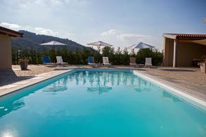 LaurianoAgriturismo Casa Matilde的蓝色的游泳池,配有椅子和山脉背景