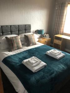 基斯高地Sinclair Bay Apartments的床上有两张折叠毛巾