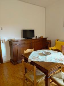圣温琴佐Costa degli Etruschi的一间带桌子和电视的用餐室