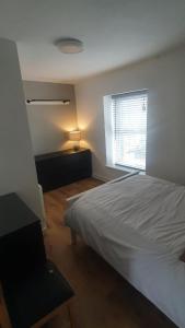 Aberaman3 Story House near Bike park Wales & zip world的卧室配有白色的床和窗户。