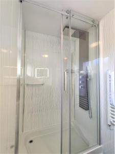 里辛Curlew's Nest的浴室里设有玻璃门淋浴