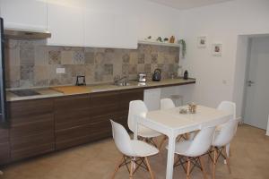 阿尔布费拉Quinta do Sr. Cabrita的厨房配有白色的桌子和白色的椅子
