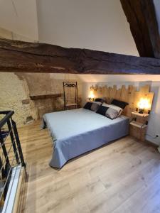 洛什Les Logis du rempart的一间卧室设有一张大床,铺有木地板