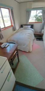 Ōgo田舎の宿 吉田屋的卧室配有床、桌子和窗户。
