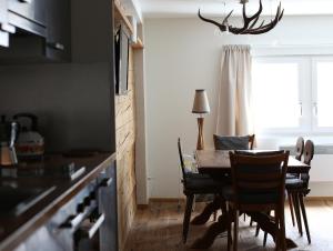 安德马特安德马特瑞士木屋酒店的厨房以及带桌椅的用餐室。